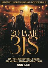 De 3JS in donkere pakken poseren in een warm verlicht theater met rijen rode stoelen en gouden lichtaccenten.