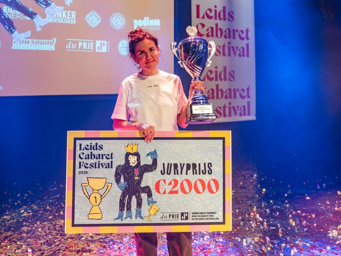 Alina Sharipova op podium houdt grote trofee vast en toont cheque met juryprijs