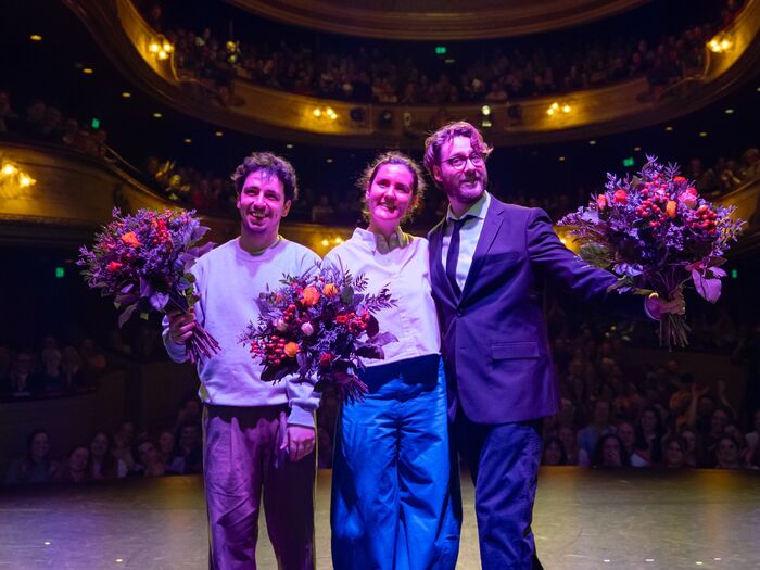 Levy, Alina & meeuw op podium voor een zaal houden bloemen vast