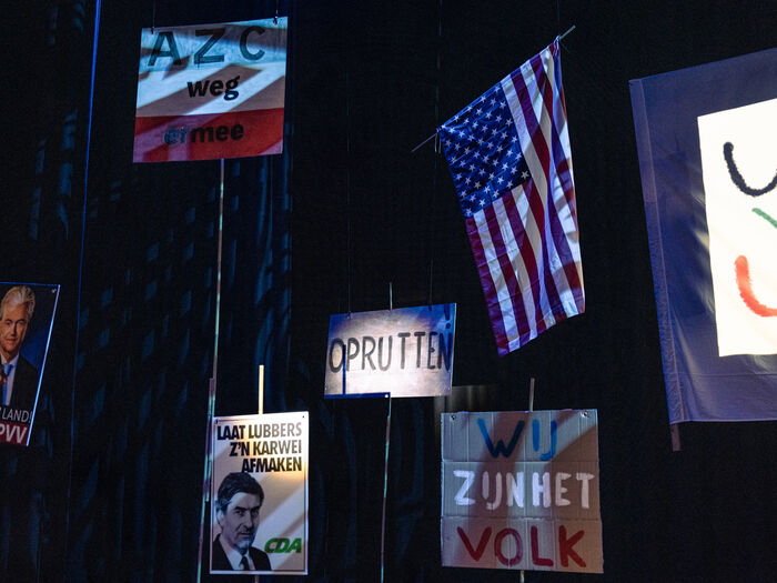 Vlaggen en spandoeken met politieke boodschappen en de Amerikaanse vlag op een evenement.