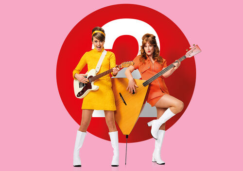 Twee performers in retro jurken spelen snaarinstrumenten voor groot rood cirkeldecor.