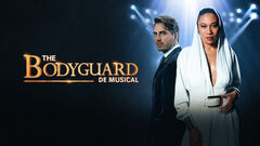 Twee hoofdrolspelers van de musical "The Bodyguard", staand in spotlight met een dramatische achtergrond.