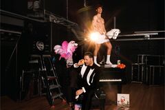 Geklede performer bij piano terwijl ander op piano poseert met speelgoedpaard.