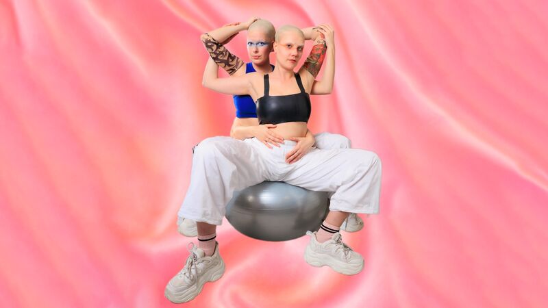 Twee personen met geschoren hoofden poseren zittend op een fitnessbal tegen roze achtergrond.