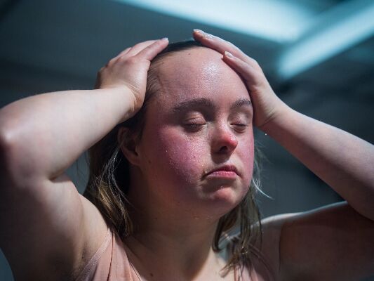 Danseres van Compagnie Tiuri staat met ogen dicht en handen in het haar