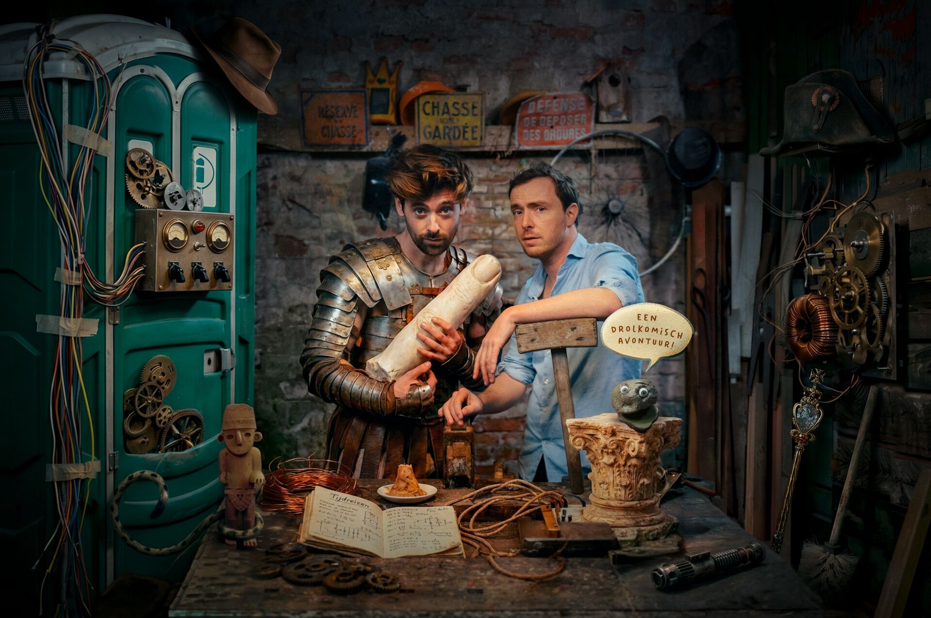 Twee mannen in een middeleeuwse werkplaats, één in harnassing met een rol perkament, de ander verdiept in een boek.