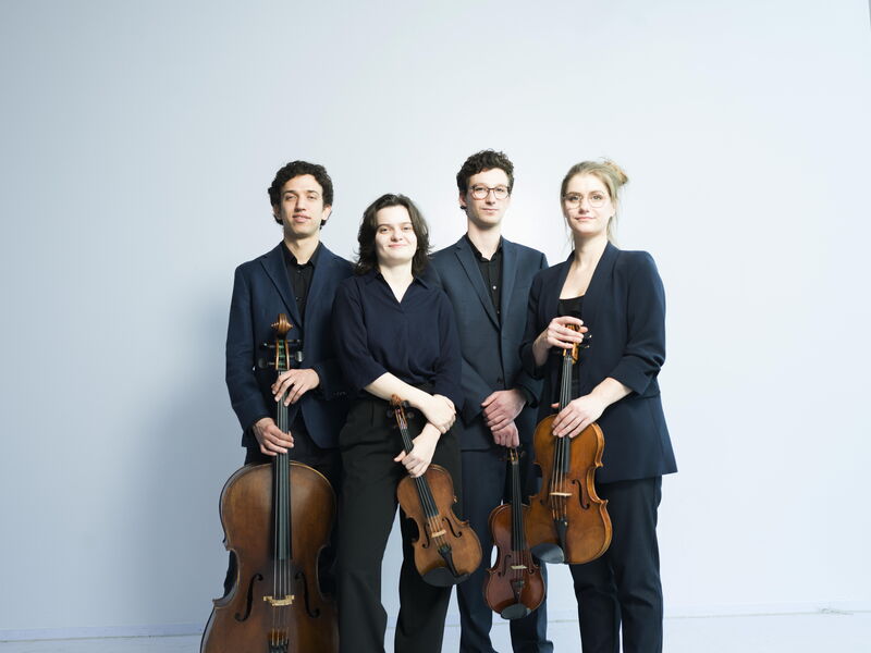 Klassiek strijkkwartet met twee violisten, een cellist en een altviolist, gekleed in zwarte outfits tegen een lichte achtergrond.