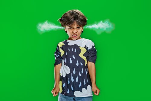 Kind staat voor felgroene achtergrond met rookwolken die uit beide oren komen.