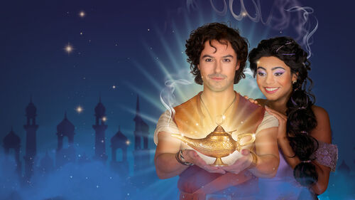 Een man en een vrouw in fantasie-outfits staan samen, met een magische sfeer en lichten op de achtergrond.